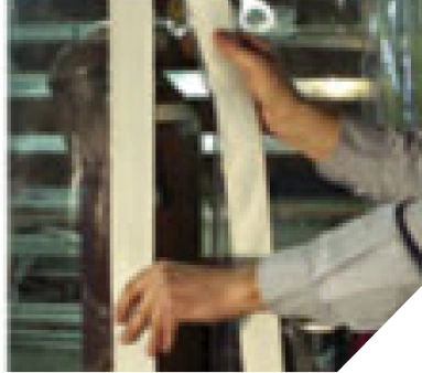 Worker applying masking tape on window frame for painting preparation