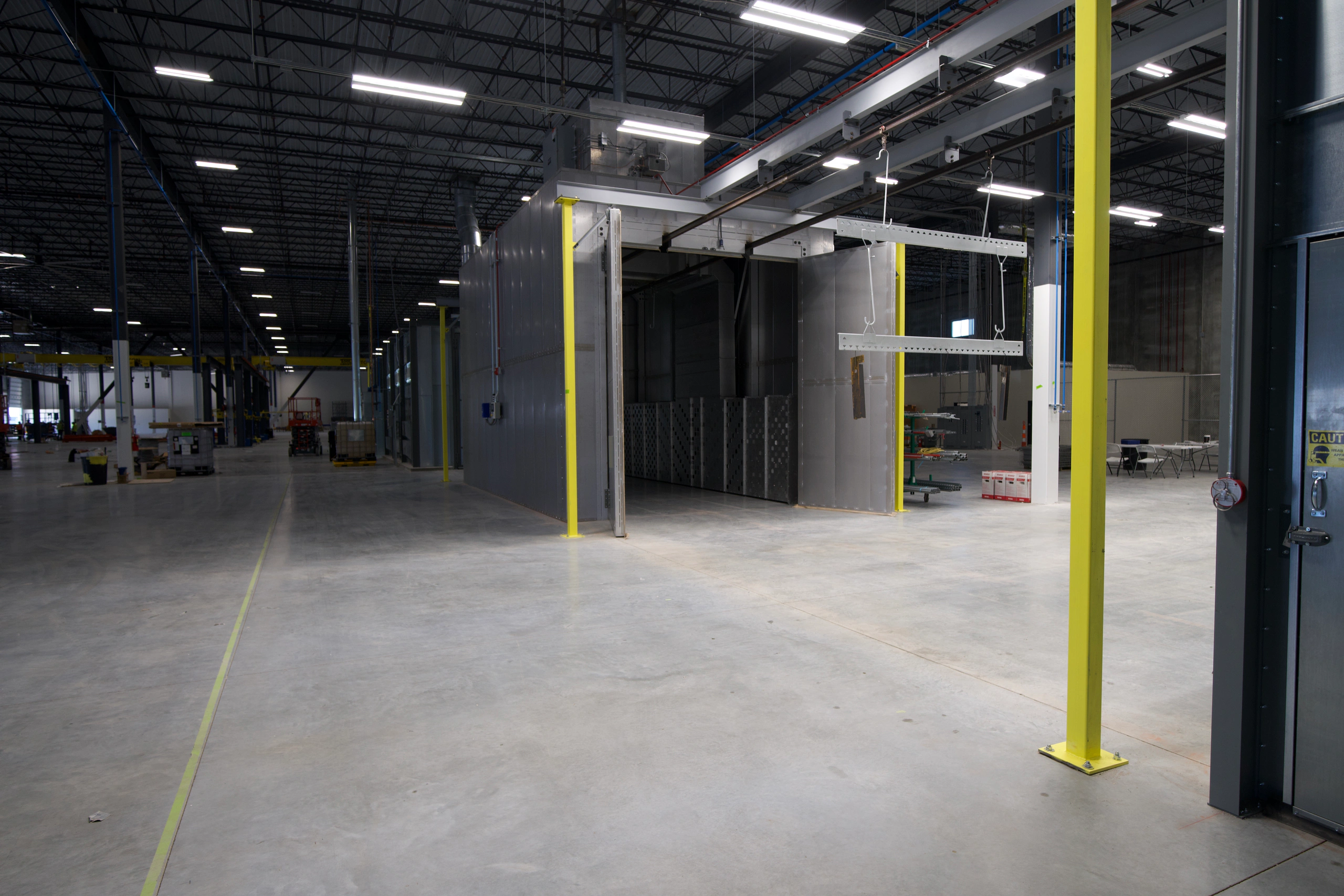 Powder coating line with conveyor and finishing equipment.