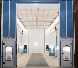 Interior view of a large industrial paint booth with ventilation and lighting