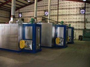 Industrial paint booth curing ovens in warehouse with exhaust ventilation