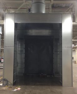 Industrial metal paint booth entrance with ventilation system in manufacturing facility