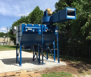 Large blue industrial paint booth dust collector installed outdoors