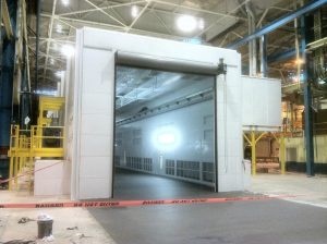 Industrial paint booth with open entrance and caution tape