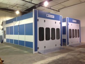 Industrial Nova Verta paint booths with blue and white exterior in a workshop