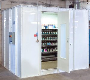 Industrial white paint booth storage room with open door showing paint containers inside