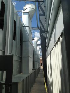 Industrial paint booth ventilation ducts installed in narrow corridor with steel framework