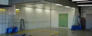 Spacious and well-lit automotive paint booth interior.