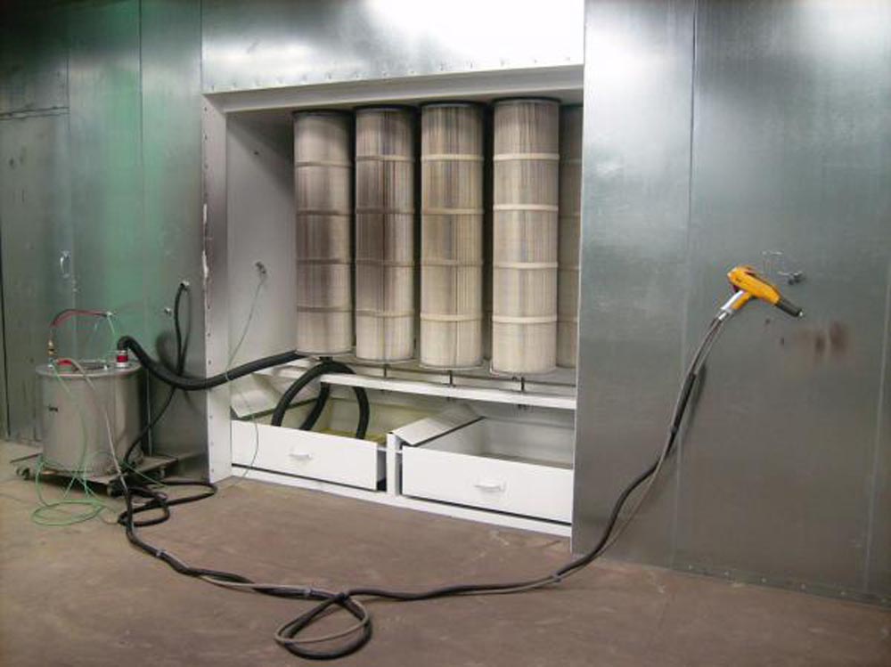 Industrial paint booth filter system with connected hoses and yellow spray gun