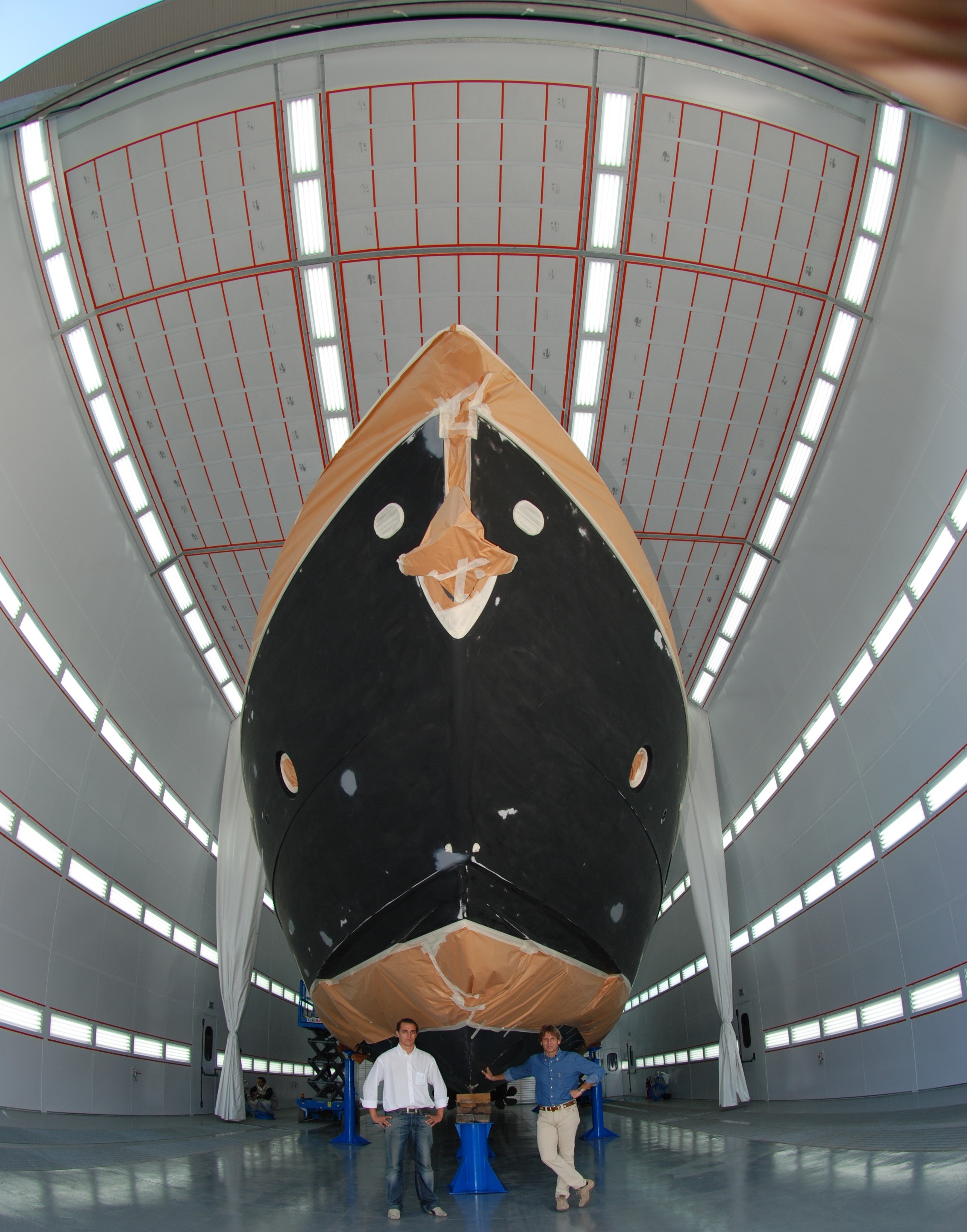 Large yacht inside a modern paint booth facility.